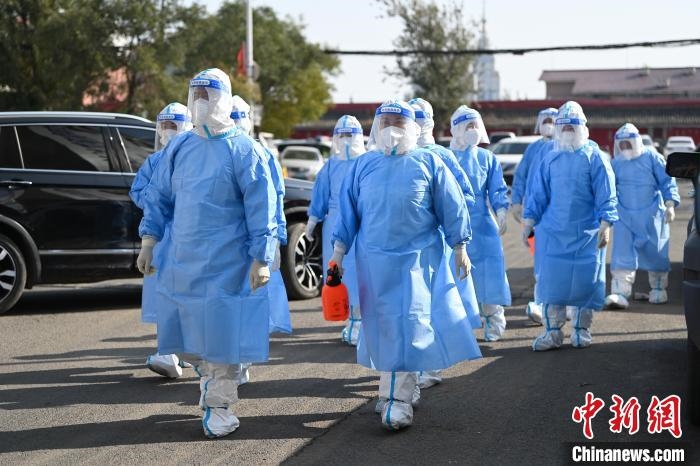 圖為醫(yī)務(wù)人員在封閉小區(qū)做防控工作?！⑽娜A 攝