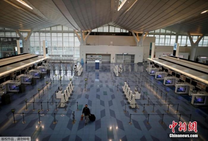 資料圖：日本東京，東京國際機場，一名乘客在國際航班航站樓的登機區(qū)。