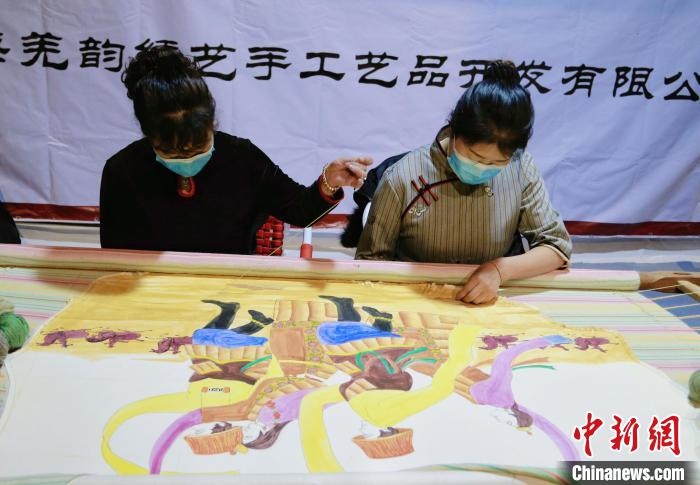 圖為皮繡藝人在市集上“秀”指尖技藝?！●R銘言 攝