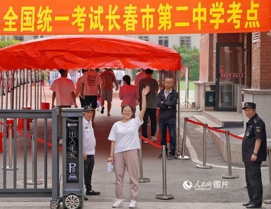 6月7日，在長(zhǎng)春市第二中學(xué)考點(diǎn)，一名考生信心滿滿進(jìn)入考場(chǎng)，并與家長(zhǎng)揮手致意。人民網(wǎng)記者 李洋攝