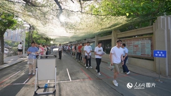 6月7日，烏魯木齊市第七十中學(xué)門口，考生們有序進(jìn)入考場(chǎng)。人民網(wǎng) 李欣洋攝