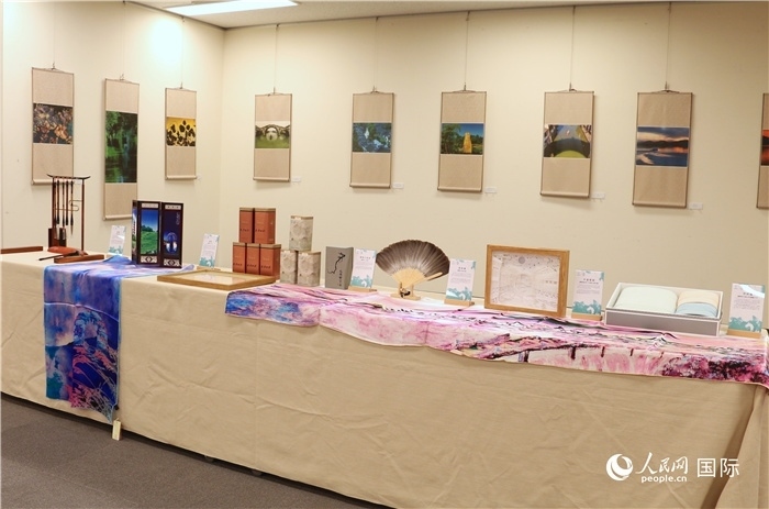 現(xiàn)場(chǎng)展出的馮學(xué)敏攝影作品與湖州市特色工藝品。（人民網(wǎng) 許可攝）