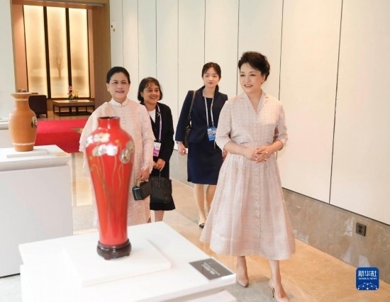 7月27日下午，國(guó)家主席習(xí)近平夫人彭麗媛在四川成都會(huì)見陪同印度尼西亞總統(tǒng)佐科來華出席第31屆世界大學(xué)生夏季運(yùn)動(dòng)會(huì)開幕式并訪華的總統(tǒng)夫人伊莉亞娜。這是彭麗媛和伊莉亞娜欣賞成都特色非遺工藝品。新華社記者 丁林 攝