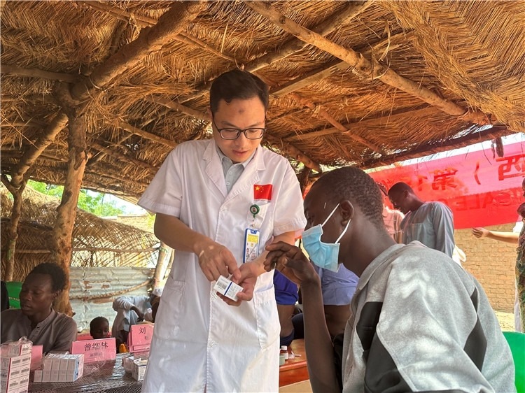圖為南昌大學(xué)第一附屬醫(yī)院病理科主治醫(yī)師張振東為村民解說藥品使用方法。中國(guó)駐乍得醫(yī)療隊(duì)供圖