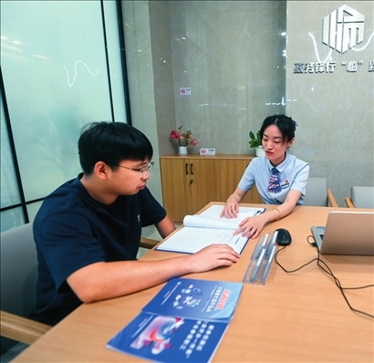 在杭州市臨安區(qū)政務(wù)服務(wù)中心的“為企服務(wù)中心”，黨員志愿者（右）解答企業(yè)主的疑問（2023年7月7日攝）。徐昱攝/本刊