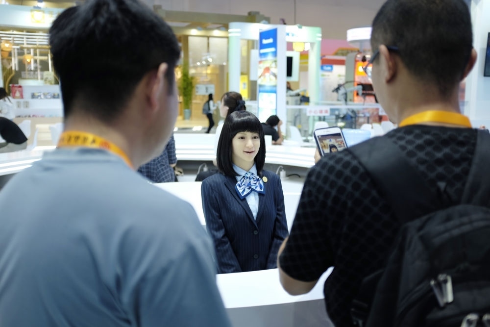 9月1日，媒體記者在國(guó)家會(huì)議中心與服務(wù)機(jī)器人互動(dòng)。新華社記者 劉夢(mèng)琪 攝