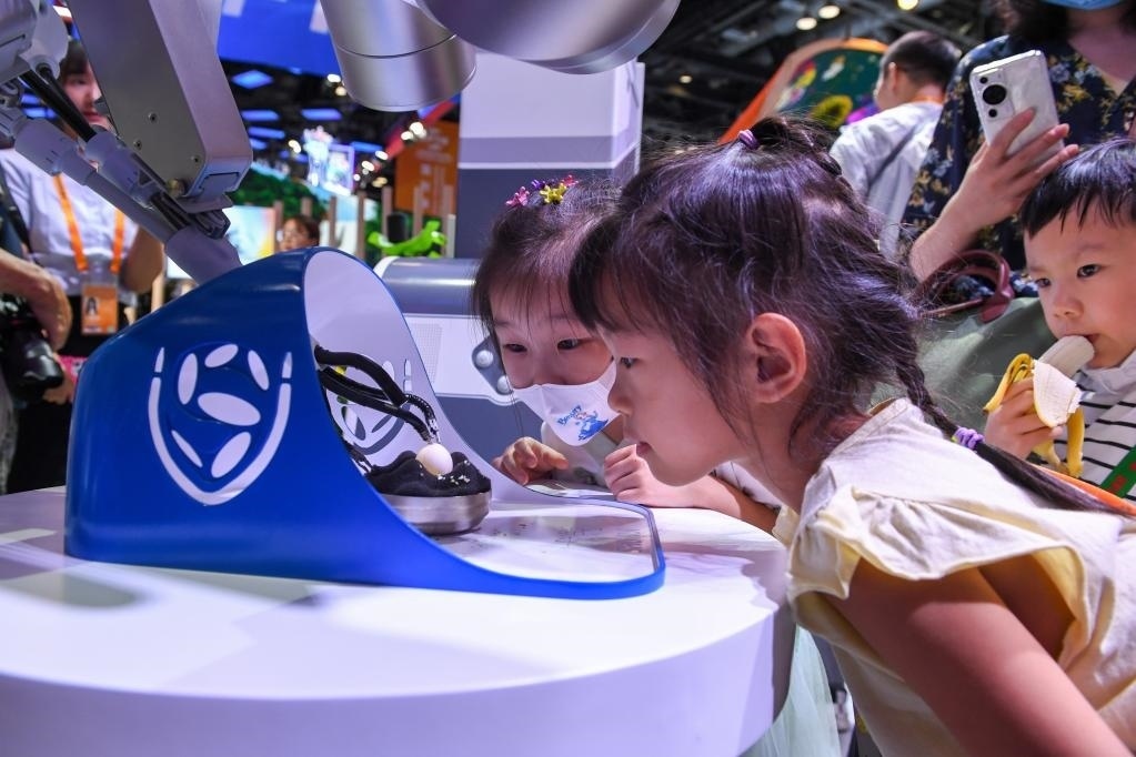 9月3日，幾名小朋友在國(guó)家會(huì)議中心觀看單孔腔鏡手術(shù)機(jī)器人展示。新華社記者 鞠煥宗 攝