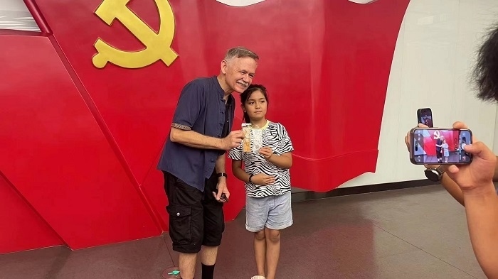 潘維廉和志愿講解員紀念合影。主辦方供圖