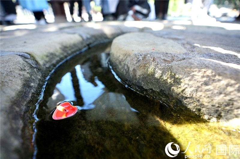 圖為水渠里流過的“桃心”蠟燭。人民網(wǎng) 盧鵬宇攝