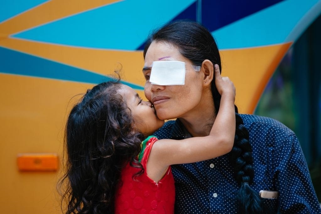 2019年3月15日，在柬埔寨磅湛省醫(yī)院，即將接受白內(nèi)障手術(shù)的患者孫美樂接受女兒的親吻祝福。在接受了中國(guó)醫(yī)療隊(duì)的白內(nèi)障義診手術(shù)后，她的視力逐步恢復(fù)，生活有了新的光明和希望。