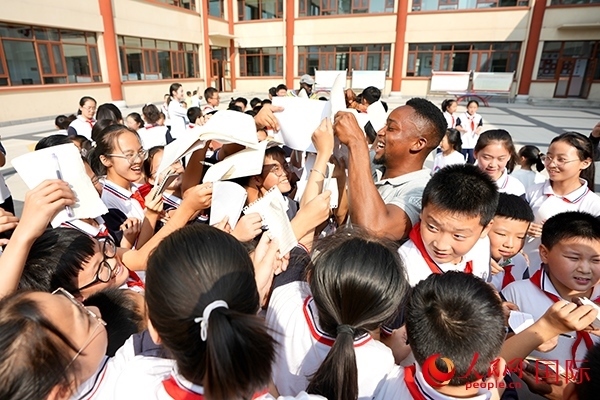 孩子們和選手互動(dòng)簽名。人民網(wǎng) 盧鵬宇攝