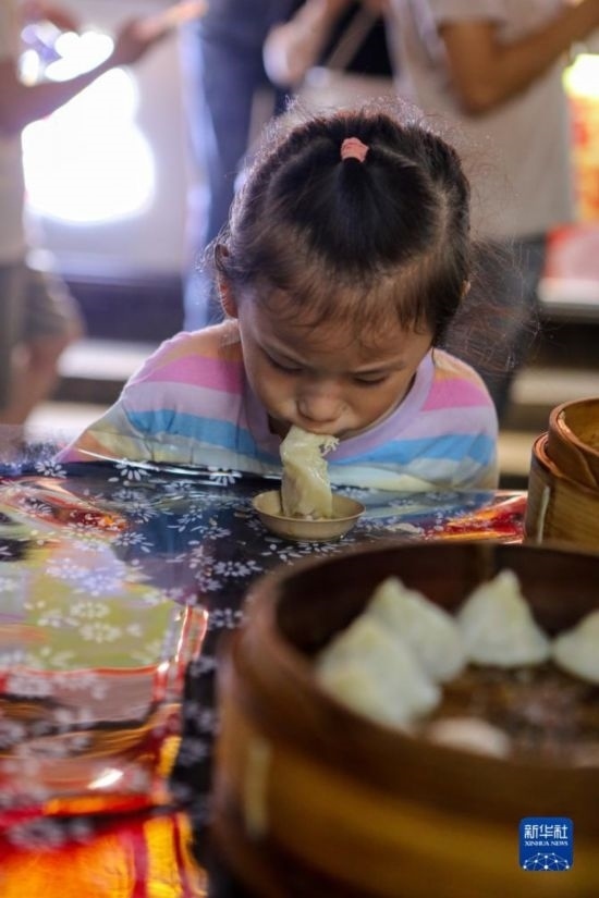 9月27日，小朋友在南翔小籠長(zhǎng)街宴上品嘗南翔小籠。