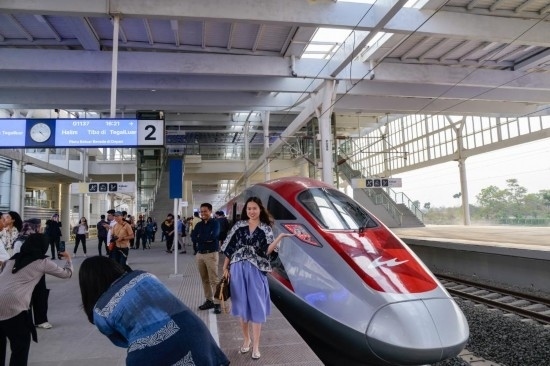  10月17日，在印度尼西亞萬隆德卡魯爾站，乘客在站臺上和雅萬高鐵高速動車組列車合影。新華社記者 徐欽 攝