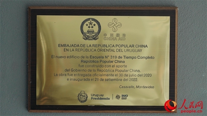 小學(xué)墻上懸掛的中國援助標(biāo)識(shí)。人民網(wǎng)記者 張若涵攝