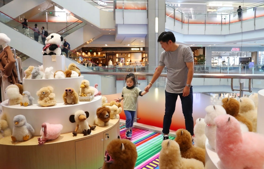 2023年11月2日，顧客在溫暖駝品牌專柜內(nèi)選購。連續(xù)六年參加進博會的秘魯羊駝制品品牌溫暖駝在上海市中心商場開設了專柜。新華社記者 方喆 攝