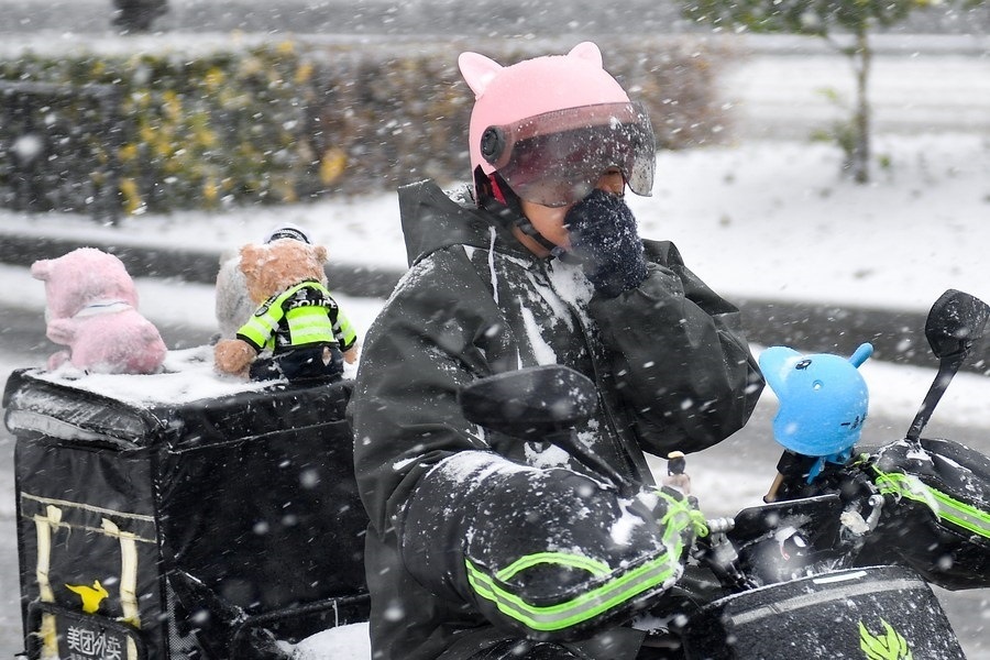 11月6日，在長(zhǎng)春市街頭，一名外賣員在雪中騎行。新華社記者 許暢 攝