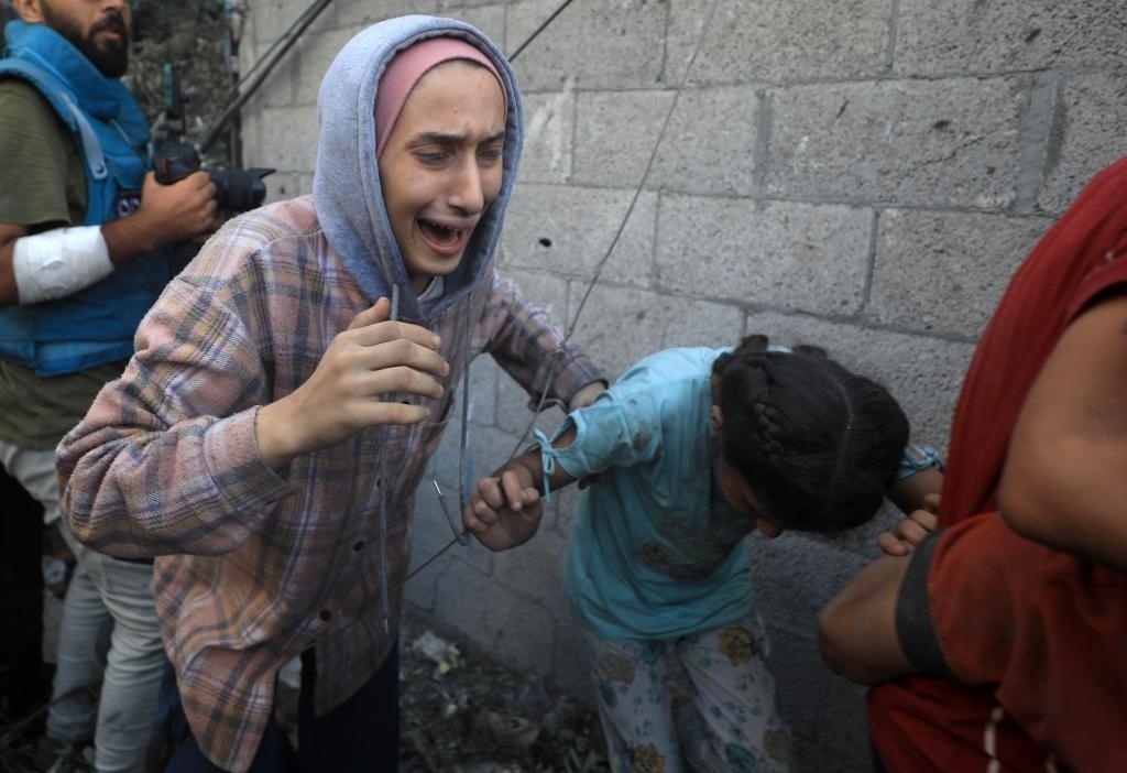 11月6日，人們從加沙地帶中部地區(qū)一處被炸難民營逃離。新華社發(fā)（亞西爾·庫迪攝）