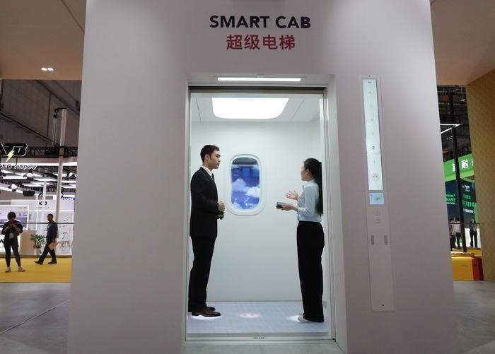 11月5日，工作人員（右）在第六屆進(jìn)博會(huì)上向參觀者介紹奧的斯公司全新推出的超級(jí)電梯。