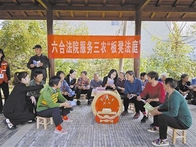  圖③：干警向附近農(nóng)戶解讀相關法律法規(guī)。