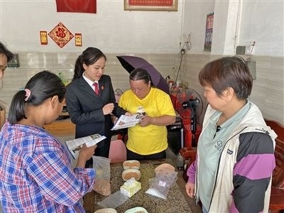  圖⑤：龍圩區(qū)法院法官到群眾家中開展法治宣傳。資料圖片