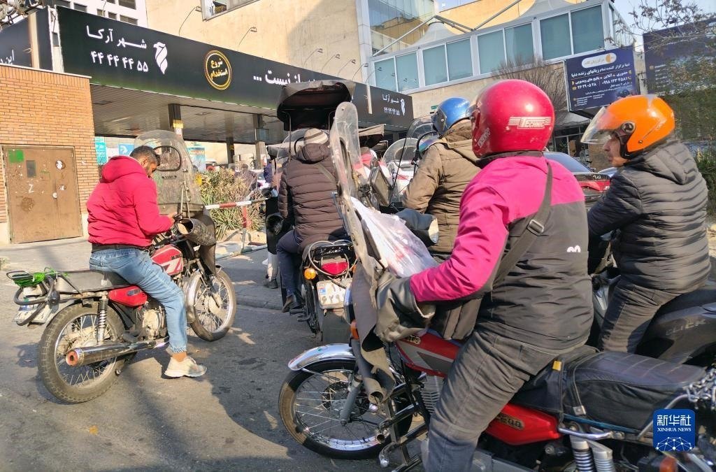 12月18日，摩托車在伊朗首都德黑蘭的一家加油站外等待加油。新華社記者 沙達(dá)提 攝