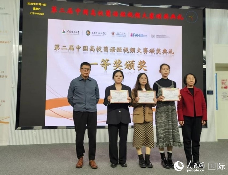 澳門大學(xué)中葡雙語教學(xué)暨培訓(xùn)中心主任姚京明（左一）和中國傳媒大學(xué)外國語言文化學(xué)院院長文春英（右一）為一等獎(jiǎng)獲得者頒獎(jiǎng)。人民網(wǎng)記者 魯揚(yáng)攝