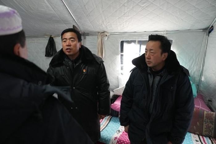 2023年12月22日，積石山縣大河家鎮(zhèn)大河村黨支部書記馬成忠（右二）在帳篷里和受災(zāi)群眾交流。新華社記者 陳斌 攝