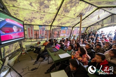 12月22日，在積石山縣大河家鎮(zhèn)大河村安置點(diǎn)，陸軍76集團(tuán)軍某旅搭建的“臨時學(xué)校”內(nèi)，小朋友正在看動畫片。人民網(wǎng)記者 翁奇羽攝