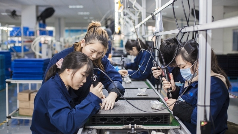 在新亞勝光電的產(chǎn)品線上，工人正進(jìn)行產(chǎn)品組建和安裝布線。受訪者供圖