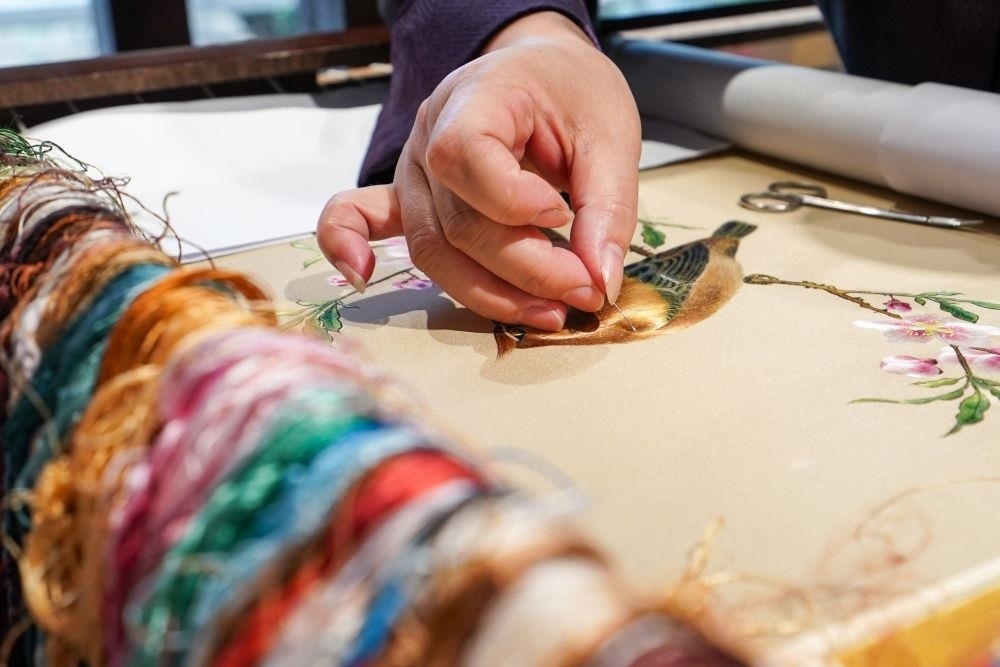 △2023年7月6日，盧建英在江蘇蘇州平江路的工作室內(nèi)刺繡。