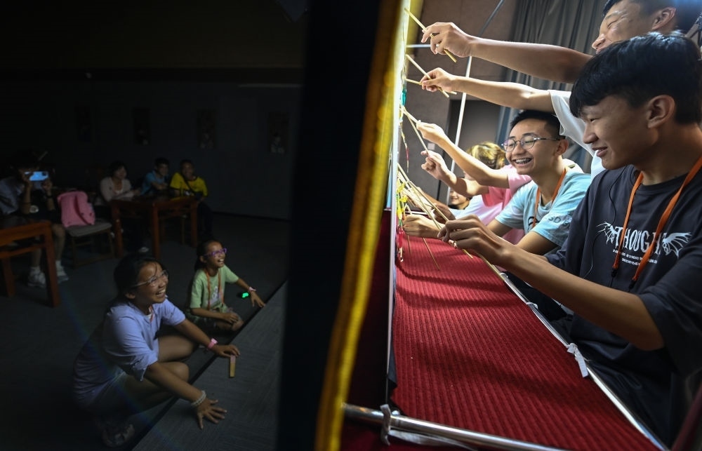 2023年8月8日，進(jìn)行暑期研學(xué)的學(xué)生在位于陜西省西安市的中國(guó)秦腔藝術(shù)博物館體驗(yàn)皮影戲演出。新華社記者 鄒競(jìng)一 攝