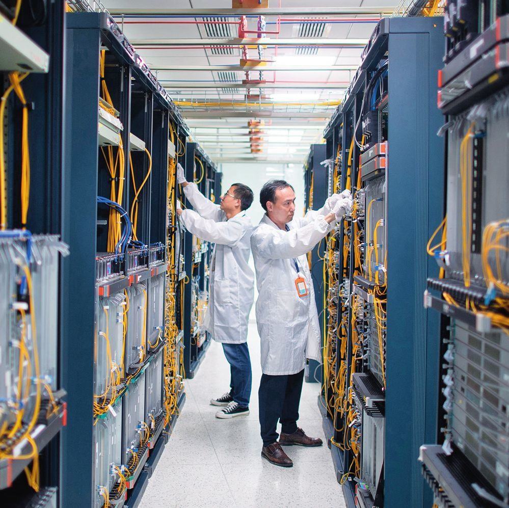 在位于武漢中國光谷的光電器件研發(fā)制造商——武漢光迅科技股份有限公司生產(chǎn)車間內(nèi)，技術(shù)人員在光模塊生產(chǎn)線作業(yè)（2023年4月11日攝）。程敏攝/本刊