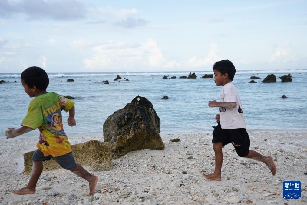 1月20日，兒童在瑙魯海邊嬉戲。新華社記者 王申 攝