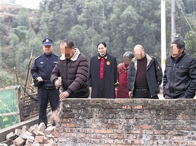  圖③：庭審結(jié)束后，在法官的見(jiàn)證下，陳某在院壩邊重新開(kāi)鑿一條通道。