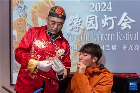 1月28日，在上海豫園舉行的民俗活動(dòng)上，美國(guó)馬斯卡廷中學(xué)學(xué)生在非遺傳承人的指導(dǎo)下吹糖偶。 新華社記者 王翔 攝