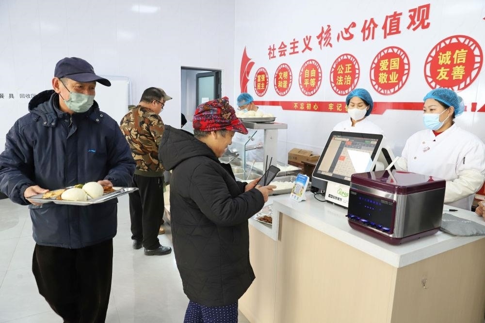 △2024年2月1日，市民在河北涿州市雙塔街道永濟(jì)秀園小區(qū)便民食堂內(nèi)購買午餐。