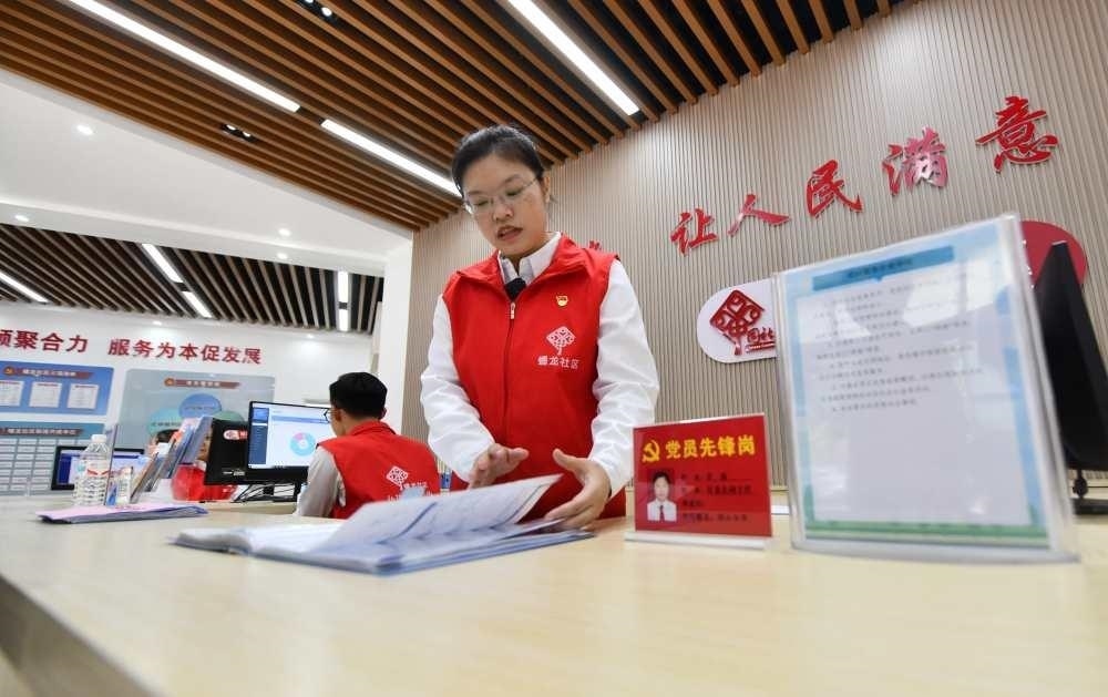 △2023年12月14日，廣西南寧市蟠龍社區(qū)，工作人員在為居民服務(wù)。