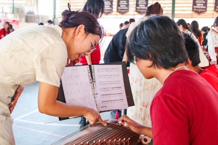 志愿者教師指導(dǎo)學(xué)生彈奏古箏?；顒?dòng)主辦方供圖