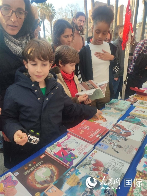 印刷精美的中國傳統(tǒng)文化叢書吸引了小游客的注意。人民網(wǎng)記者鄭彬攝