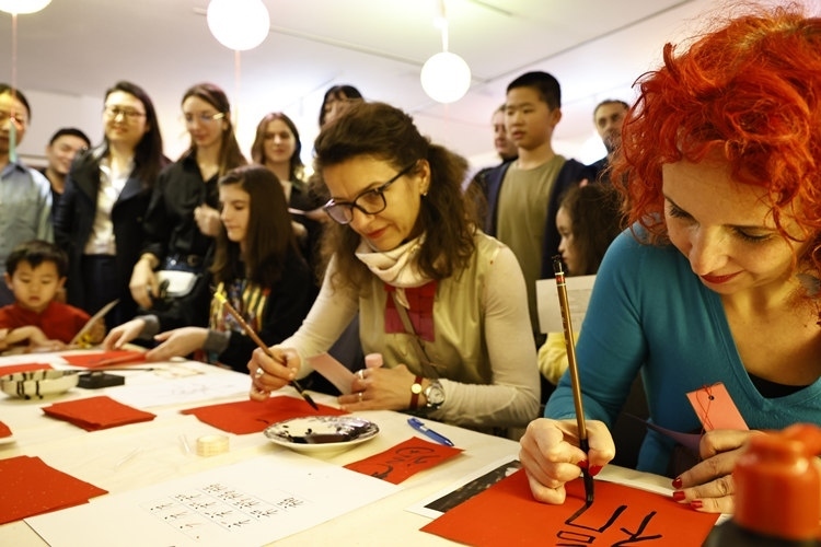 羅馬尼亞觀眾學(xué)習(xí)用毛筆寫(xiě)“?！弊?。中國(guó)文化中心供圖