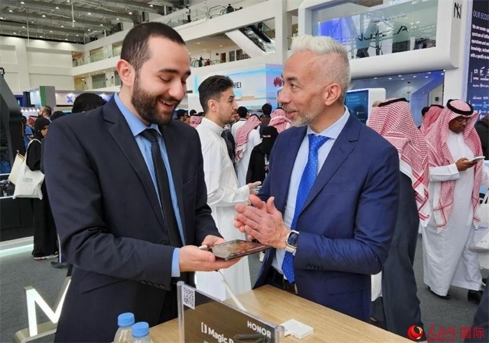 兩名觀眾在榮耀手機(jī)展臺(tái)前交流。人民網(wǎng)記者 管克江攝