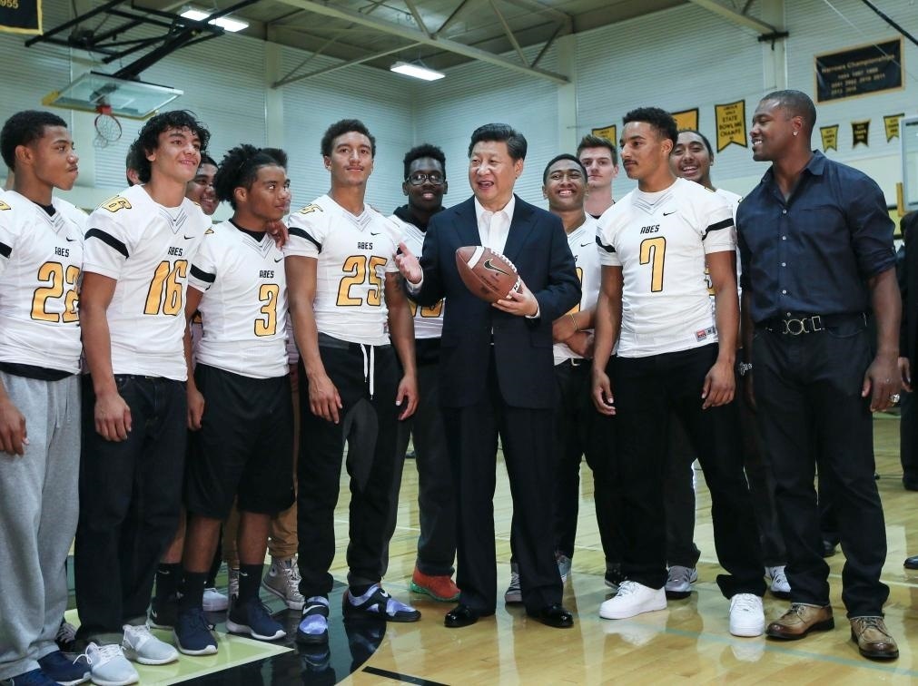 2015年9月23日，國家主席習(xí)近平參觀美國塔科馬市林肯中學(xué)。這是習(xí)近平在學(xué)校體育館，同上橄欖球訓(xùn)練課的學(xué)生們親切交談。新華社記者 蘭紅光 攝