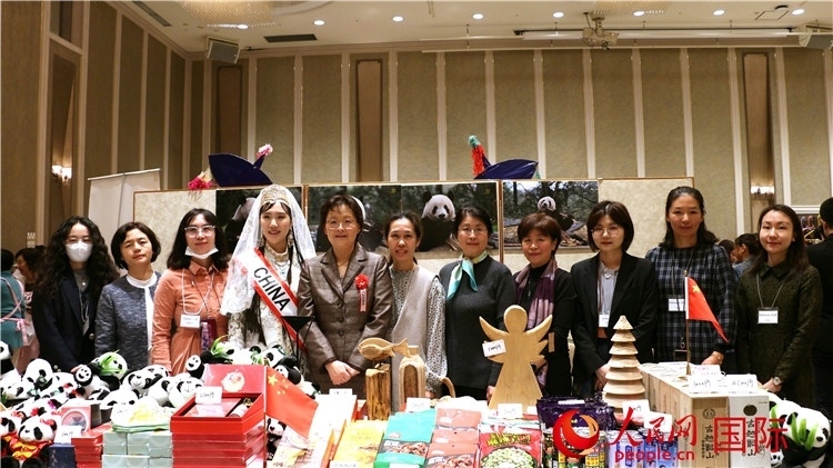 中國駐日本大使吳江浩夫人丁玥（左五）與使館人員在展位前合影留念。人民網(wǎng) 許可攝