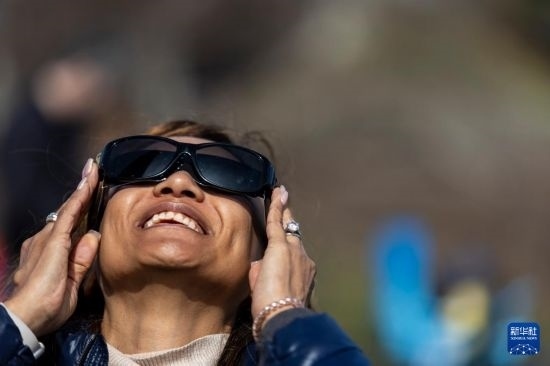 4月8日，一名女子在美國(guó)紐約州普拉茨堡觀看日食。新華社發(fā)（文森特·約翰遜攝）