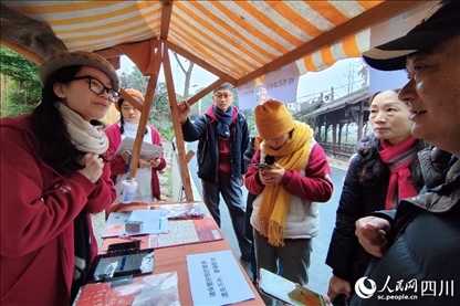 1月6日，“2024成都蒲江柑甜采摘節(jié)”上，記者見到了小萌（左一）和許多年輕人忙著做訪客接待、現(xiàn)場布置、票務(wù)核對、采摘服務(wù)等工作。人民網(wǎng)記者朱虹攝