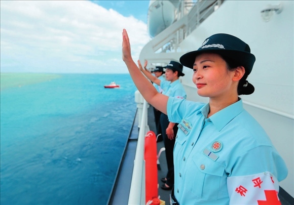 中國海軍“和平方舟”號醫(yī)院船結(jié)束訪問湯加時，任務(wù)官兵中的文職人員向歡送人群揮手告別（2023年8月4日攝）。徐巍攝/本刊