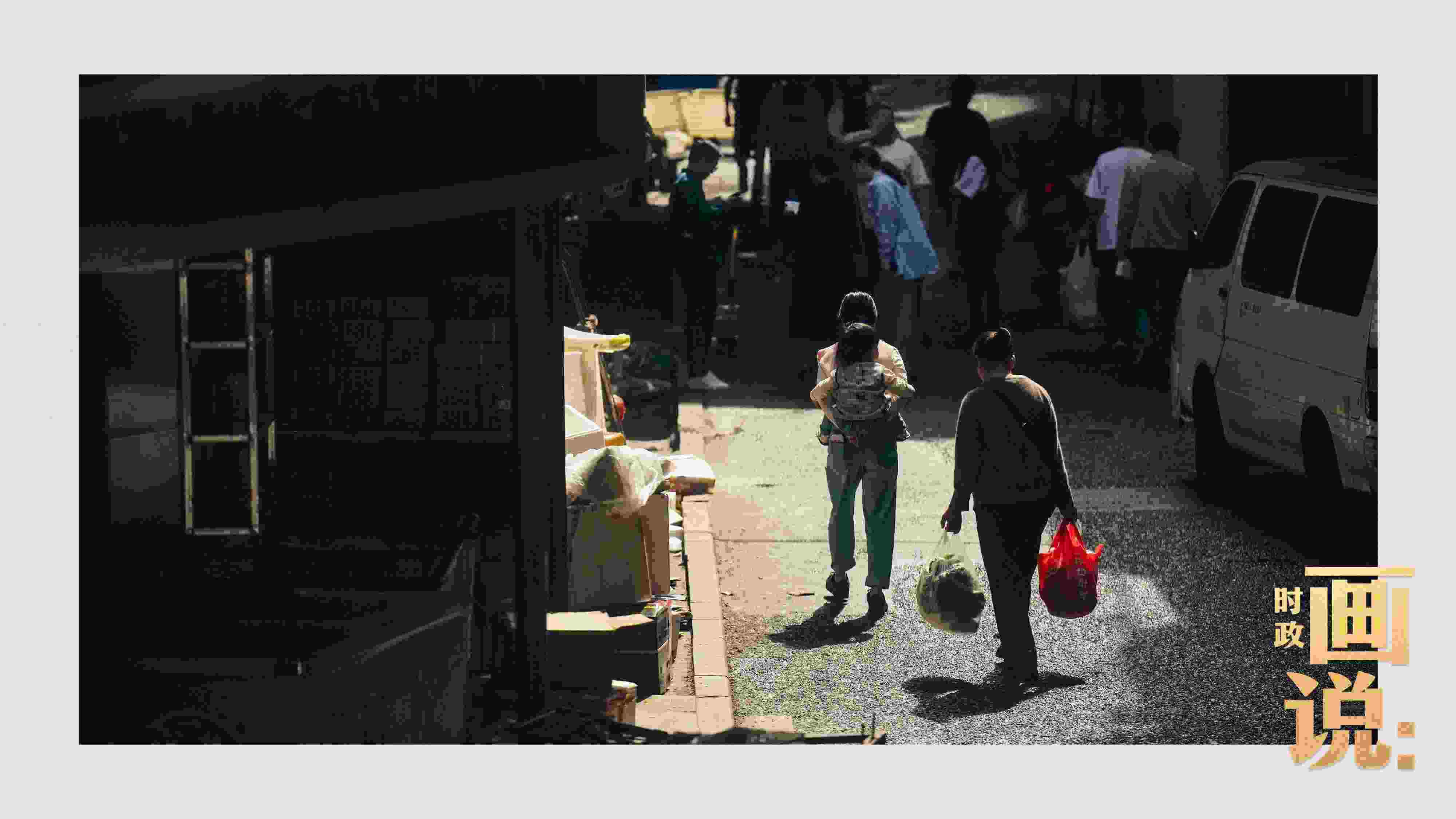 △老城區(qū)鱗次的樓宇間漏下一縷光，路人走過(guò)暖陽(yáng)。