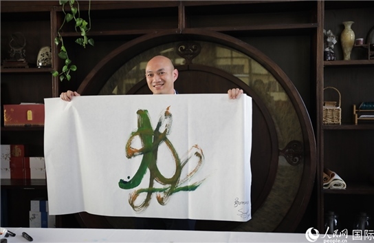 老撾駐華大使館三秘明君參加《五百筆·瀾湄合作》集體藝術(shù)創(chuàng)作。人民網(wǎng)王婧攝。