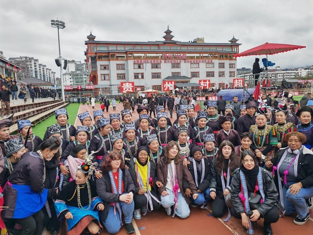 法國青年在“村超”賽場邊與參加表演的村民合影。新華社記者 羅羽 攝