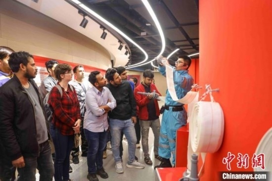 5月9日，工作人員指導留學生正確使用消防水帶。張鷹 攝